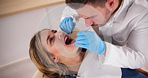 Dentist Treating Teeth Of Young Pregnant Woman Patient Lying