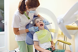 Dentist treats a child`s teeth to a boy in a dental office