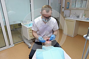 Dentist treats teeth to a young girl in a dental office