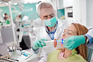 Dentist used instrument with light to dry and strengthen dental