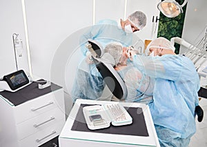 Dentist using dental implant machine during implantology procedure.