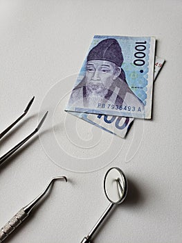 dentist utensils for oral review and south korean banknote of 1000 won