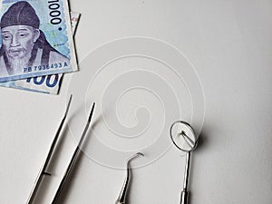 dentist utensils for oral review and south korean banknote of 1000 won