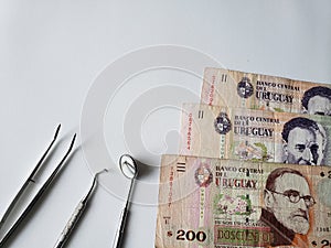 dentist utensils for oral review and uruguayan banknotes