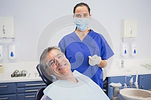 Dentist wearing surgical mask with a smiling patient