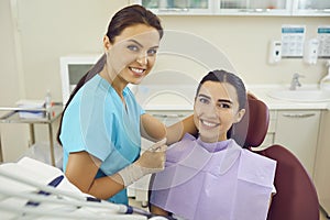 Dentist and woman patient smiling during teeth examination in dentist office