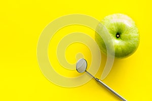Dentist work desk with mirror and apple on yellow background top view mockup