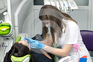 Dentist at work examining woman`s teeth