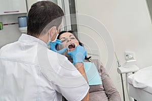 Dentist working with female patient close up