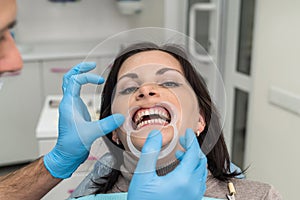 Dentist working with female patient close up