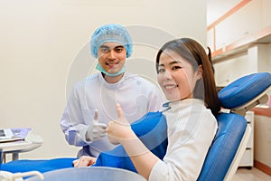 Dentist young Indian and Asian patient looking camera while thumb up to excellently