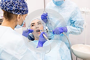 Dentistry concept. Professional dental services and modern equipment without pain. A doctor with an assistant treats