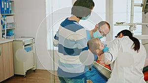 Dentistry doctors cleaning teeth of child, treating dental problems