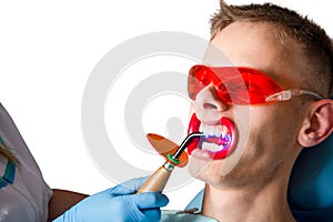 Dentistry. Polymerization of fillings with an ultraviolet lamp close-up.