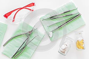 Dentists accessories. Tools, safety glasses and pills on white background top view