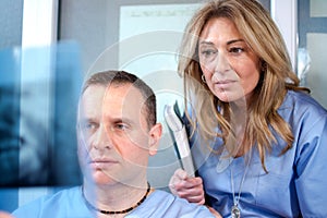 Dentists examining patient's teeth X-Ray image in dental office.