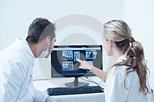 Dentists looking at x-ray on computer photo