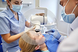 Dentists and patient with dental x-ray machine