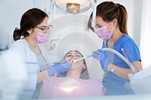 Dentists and patient in dentist office photo