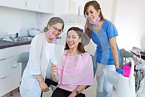 Dentists and patient in dentist office photo