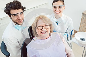 Dentists and patient in surgery looking at camera