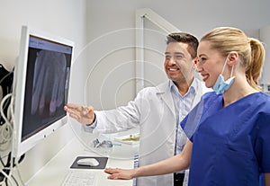 Dentists with x-ray on monitor at dental clinic