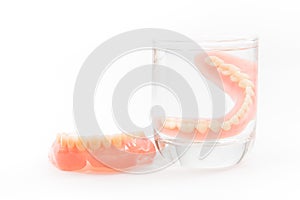 Denture is cleaned in a glass of water. proper hygiene. photo