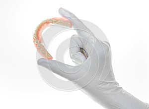 Denture and handglove on white background