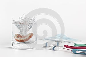 Dentures concept with glass, mask and toothbrush