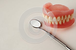 Dentures and dentist tools on a white background with copy space