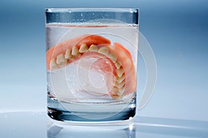 Dentures in water glass photo