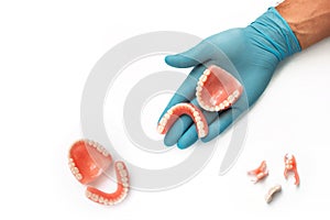 Dentures on a white background. The dentist is holding dentures in his hands.