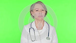 Denying Old Female Doctor Shaking Head to Stop on Green Background