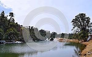 Deoria or Deoriya Tal Lake with Surrounding Trees and Snow - Winter Himalayan Landscape, Uttarakhand, India