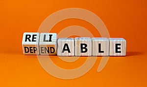 Dependable or reliable symbol. Turned wooden cubes and changed the word dependable to reliable. Beautiful orange background, copy