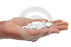 Dependant on medication. Cropped view of a mans hand holding out some white pills.
