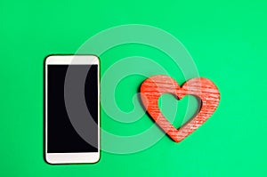 Dependence on social networks. phone smartphone and heart on a green background. online dating, flirting, message and calling your