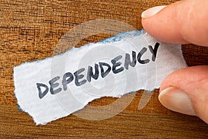 Dependency concept and theme written on old paper on a grunge background