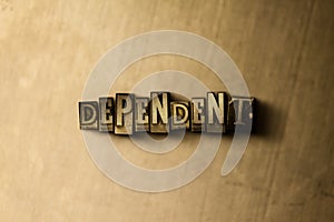 DEPENDENT - close-up of grungy vintage typeset word on metal backdrop photo