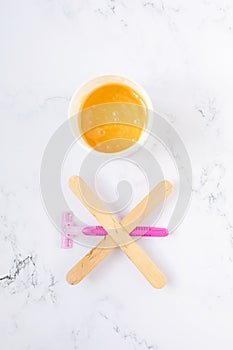 depilation and beauty concept - sugar paste or wax honey for hair removing with wooden waxing spatula sticks