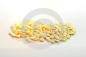 depilatory pearly yellow solid wax beans isolated on white background.