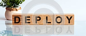 DEPLOY word written on wooden cubes, concept photo