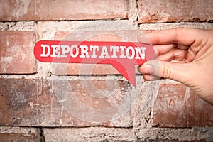 Deportation. Red speech bubble with text on a red brick background