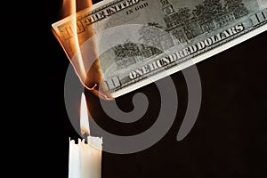 Depreciation of money, high inflation concept, 100 dollar bill burns in fire