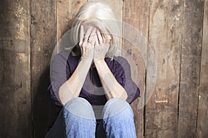 Depress senior person with wood background