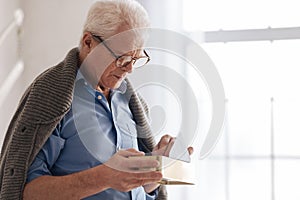 Depressed aged man putting old letters in the box