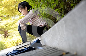 Depressed asian child girl disappointed with her exam at primary school,female student sitting alone,sad schoolgirl feel stressed, photo