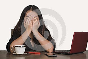 Depressed Asian Korean business woman working in stress at office computer desk feeling frustrated suffering headache and depressi