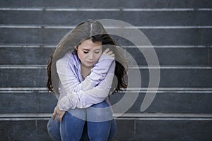 Depressed Asian Korean student woman or bullied teenager sitting outdoors on street staircase overwhelmed and anxious feeling