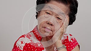 Depressed Asian senior woman lonely disappointed and lose memory in isolated white background. Portrait old woman ill sick